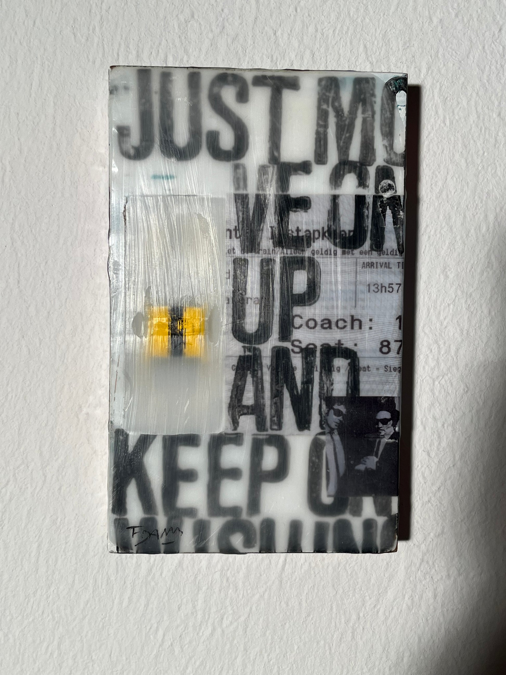 Glass block with text 'JUST KEEP YOUR EYES UP AND KEEP MOVING' on a textured white background
